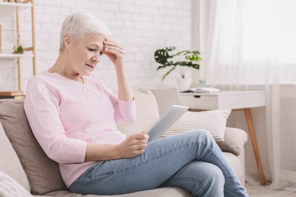 Frau informiert sich am Tablet über Augenlasern
