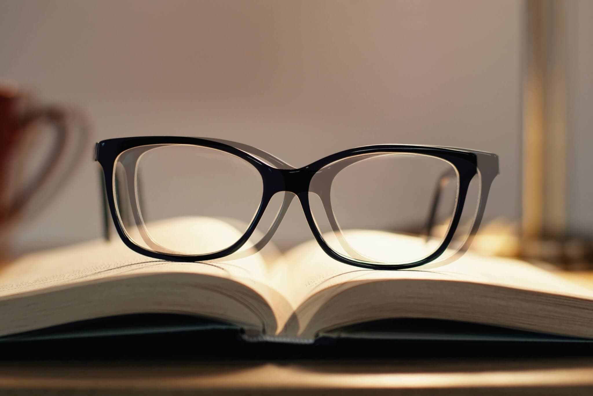 Plötzlich schlechtes Sehen, Brille im Doppelbild auf einem Buch