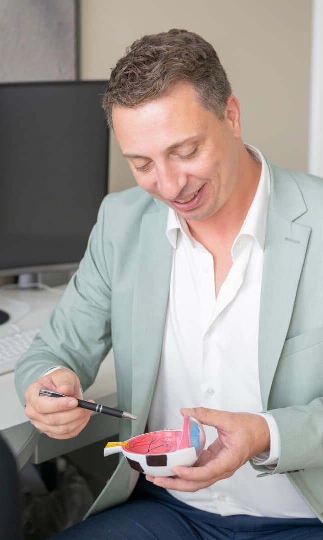 Priv.-Doz. Dr. med. Johannes Gonnermann zeigt ein Modell des Inneren eines Auges